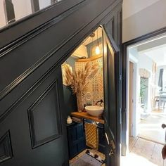 an open door leading to a bathroom with a sink and mirror on the wall next to it