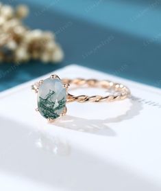 a white and green ring sitting on top of a table next to some corals