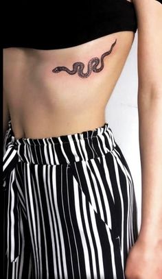 a woman's stomach with a snake tattoo on her left side ribcage