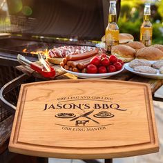 a bbq grill with hot dogs, hamburgers and other foods on the table