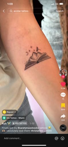 a person with a tattoo on their arm and an open book in front of them