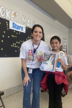 two women standing next to each other holding up an award for their work on the rocket