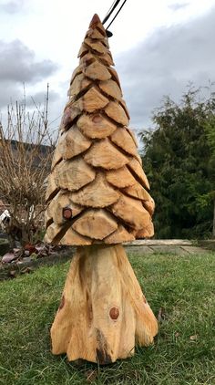 a wooden christmas tree sitting on top of a lush green field