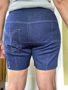 the back of a person wearing blue shorts