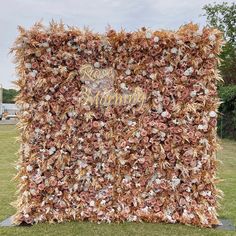 a decorative wall made out of leaves and flowers in the shape of a heart with words written on it