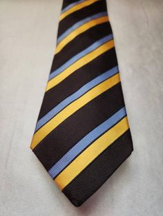 "Hemley Men's striped necktie. Beautiful and sought after Hemley necktie - from 100% silk. The label reads: Hemley 100 % Silk Made in Germany. Colors: Black, blue & yellow. Fabric: 100% Silk Condition: Very good vintage condition. Length: 58\"  Width at the widest point: 4\" Please note, that this vintage item is pre-owned. Due to different screen properties, colors may slightly vary from the photo. Thanks for looking!" Tie Men's, Mens Stripes, Mens Neck Ties, Yellow Fabric, Silk Ties, Necktie, The Label, Blue Yellow, Black Blue