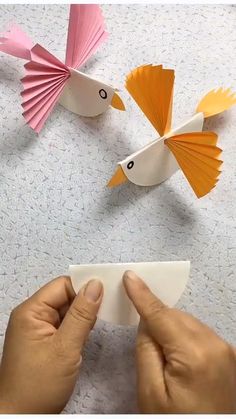 someone is making some paper birds on the table