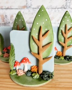 three cookies with trees and mushrooms on them