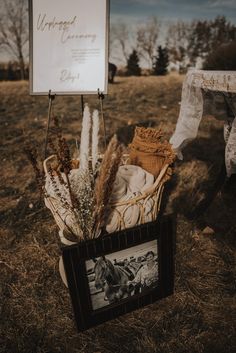 a basket filled with dried plants next to a sign