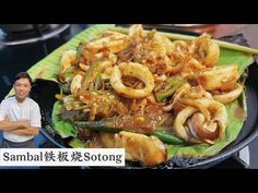 a man standing in front of a plate of food on a table with chopsticks