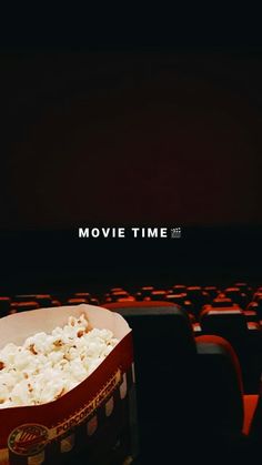 a box of popcorn sitting in front of a computer keyboard with the words movie time on it