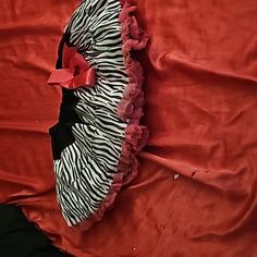 a zebra print dress laying on top of a red sheet