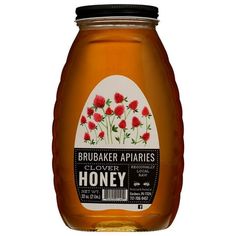 a jar of honey with red flowers on the top and white label in the bottom