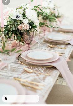 the table is set with pink and white flowers