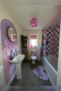 a bathroom with pink and purple decor on the walls