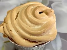 a cupcake with frosting sitting on top of a table