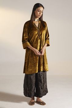 Gold kurta with floral embroidered placket. Paired with black in gold floral print palazzo.
Component: 2
Pattern: Embroidery, Printed
Type Of Work: Floral
Neckline: Mandarin collar
Sleeve Type: Three quarter
Fabric: Velvet
Color: Gold
Other Details: 
Approximate Product Weight (in kg): 2
Embroidered placket
Note:
Dupatta worn by the model is not for sale
Outfit worn by the model on right is not for sale
Since all our products are sustainable and touched by human hands for weaving, block printing Collar Kurta, Velvet Kurta, Velvet Embroidery, Palazzo Set, Embroidery Floral, Gold Velvet, Velvet Color, Gold Floral, Mandarin Collar