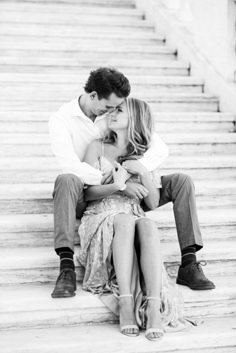 a man and woman sitting on steps kissing