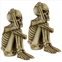 two skeleton figurines sitting next to each other