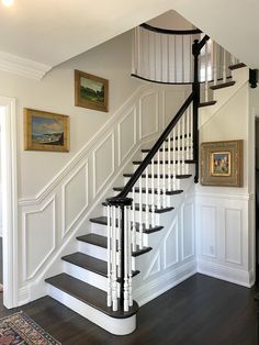 a white staircase with black handrails in a home's entryway area