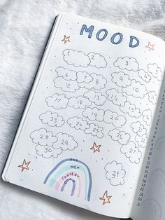 an open notebook with the words mood written on it and rainbows in the background