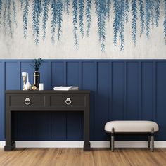 a blue and white room with a bench, table and wall hangings on the walls