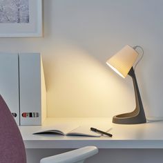 a desk lamp sitting on top of a white desk next to a computer monitor and keyboard