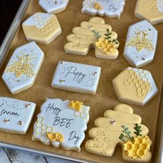 decorated cookies in the shape of honeycombs on a cookie sheet with happy bee day written on them