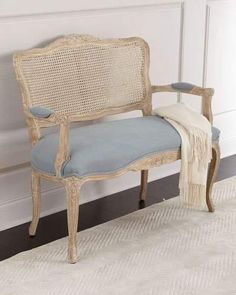 a chair with a blue cushion on top of it in front of a white wall