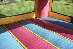 an inflatable bounce house with pink and blue sheets