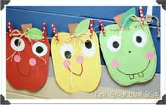 three paper apples hanging on a line with some string attached to the sides and eyes