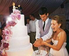 a man and woman cutting into a wedding cake