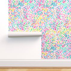 an empty room with a white wall and colorful paint sprinkles on the wall