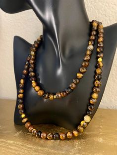 A lot of style and a lot more meaningful. This one is for him or her. ✨ Made with high quality Tigers Eye gemstones, with a few added gold accent beads.  Tigers Eye is a beautiful and powerful stone and symbol of focus and clarity. It's known to help enhance self confidence and self awareness, which can help strengthen Will power and integrity.  One necklace per order Comes in two Sizes Short: Adjustable from 14in to 16in Long: 24' Spiritual Amber Beaded Necklaces With Natural Stones, Spiritual Hand-strung Amber Beaded Necklaces, Spiritual Amber Beaded Necklace With Natural Stones, Amber Necklaces With 8mm Beads For Gift, Spiritual Amber Polished Beads Jewelry, Amber Bead Necklace 8mm As Gift, Spiritual Brown Gemstone Beads, Amber Necklace With 8mm Beads For Gift, Spiritual Gold Beads Gems And Cabochons With Natural Stones