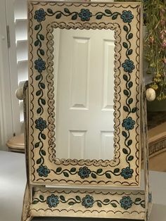 an ornately decorated mirror sits on a table