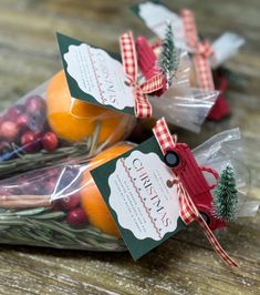 three bags filled with oranges and cranberries on top of a wooden table