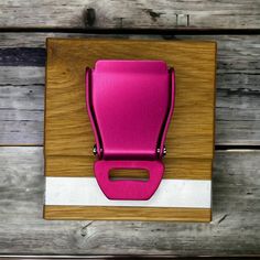 a pink chair sitting on top of a wooden floor next to a white and brown wall