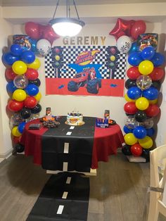 a birthday party with balloons and decorations in the shape of a monster truck on a race track