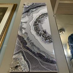 an abstract glass piece on display next to a framed painting and other art work in a museum