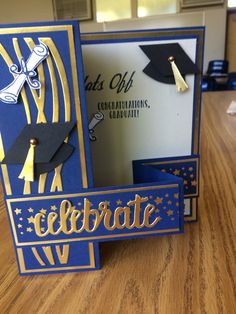 congratulations card with graduation cap and tassels on the front, in blue and gold