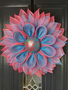 a pink and blue mesh flower on a black door