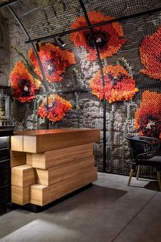 a kitchen with orange flowers on the wall and wooden counter tops in front of it