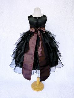 Beautiful organza ruffled dress tailor-made and ready to impress at any upscale event! Handcrafted with the upmost of care and attention to detail, we make sure that each dress is perfectly one of a kind for your little girl. Bridal satin top followed by a satin sash for a nice and snug fit Comes with a flower and matching colored sash. The skirt has layers of cut organza strips which are sewn onto the lining to create the ruffled effect The organza is then sewn at the edges to create those cris Black Sleeveless Princess Dress For Dress-up, Black Fitted Sleeveless Princess Dress, Black Ruffled Dresses For Pageants, Fitted Black Birthday Dress, Black Princess Dress With Ruffles For Birthday, Black Party Dress With Sashes, Sleeveless Black Dress For Birthday, Black Sleeveless Dress For Birthday, Black Princess Style Tutu Dress For Birthday