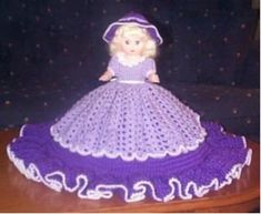 a crocheted doll sitting on top of a wooden table next to a couch