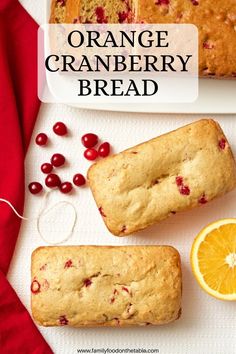 orange cranberry bread on a white plate next to an orange slice and cherries