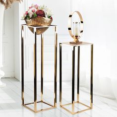 two gold side tables with flowers on them