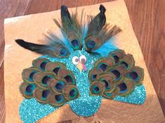 a paper bag with a peacock on it and some feathers sticking out of the top