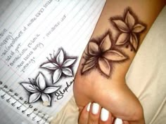 a woman's foot with flowers on it and writing paper in the back ground