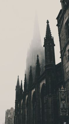 an old church in the fog with tall spires