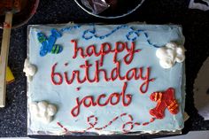 a birthday cake with white frosting that says happy birthday jacob